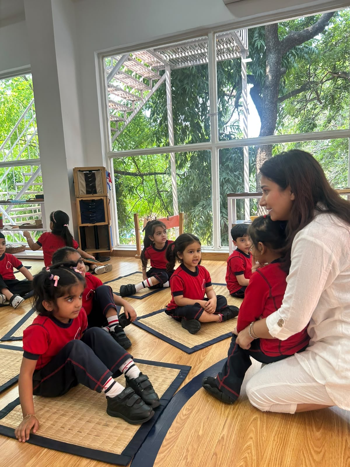 Spardha Chaturvedi talking with children seated in a classroom circle