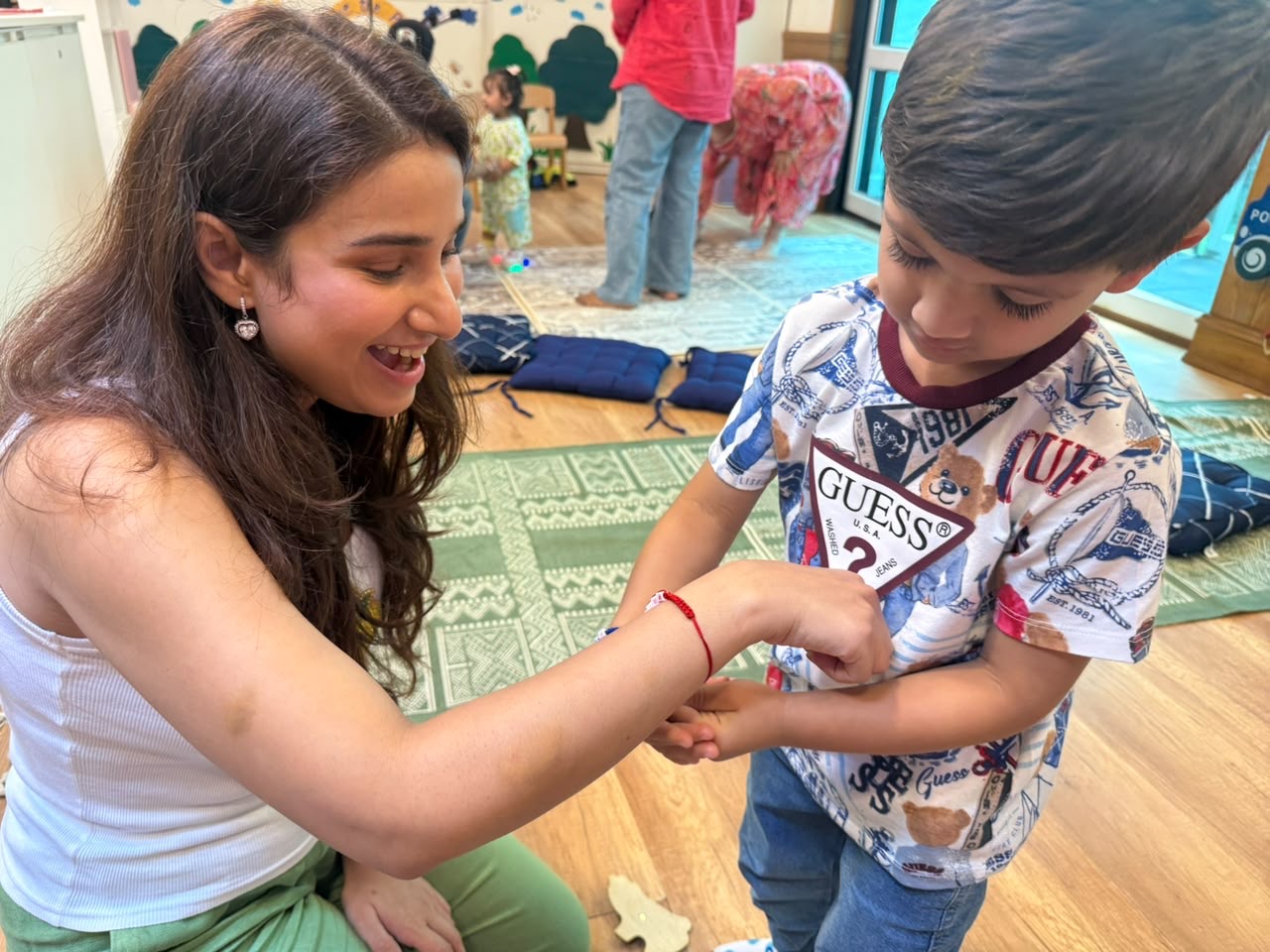 Educator tying a thread on a child's wrist