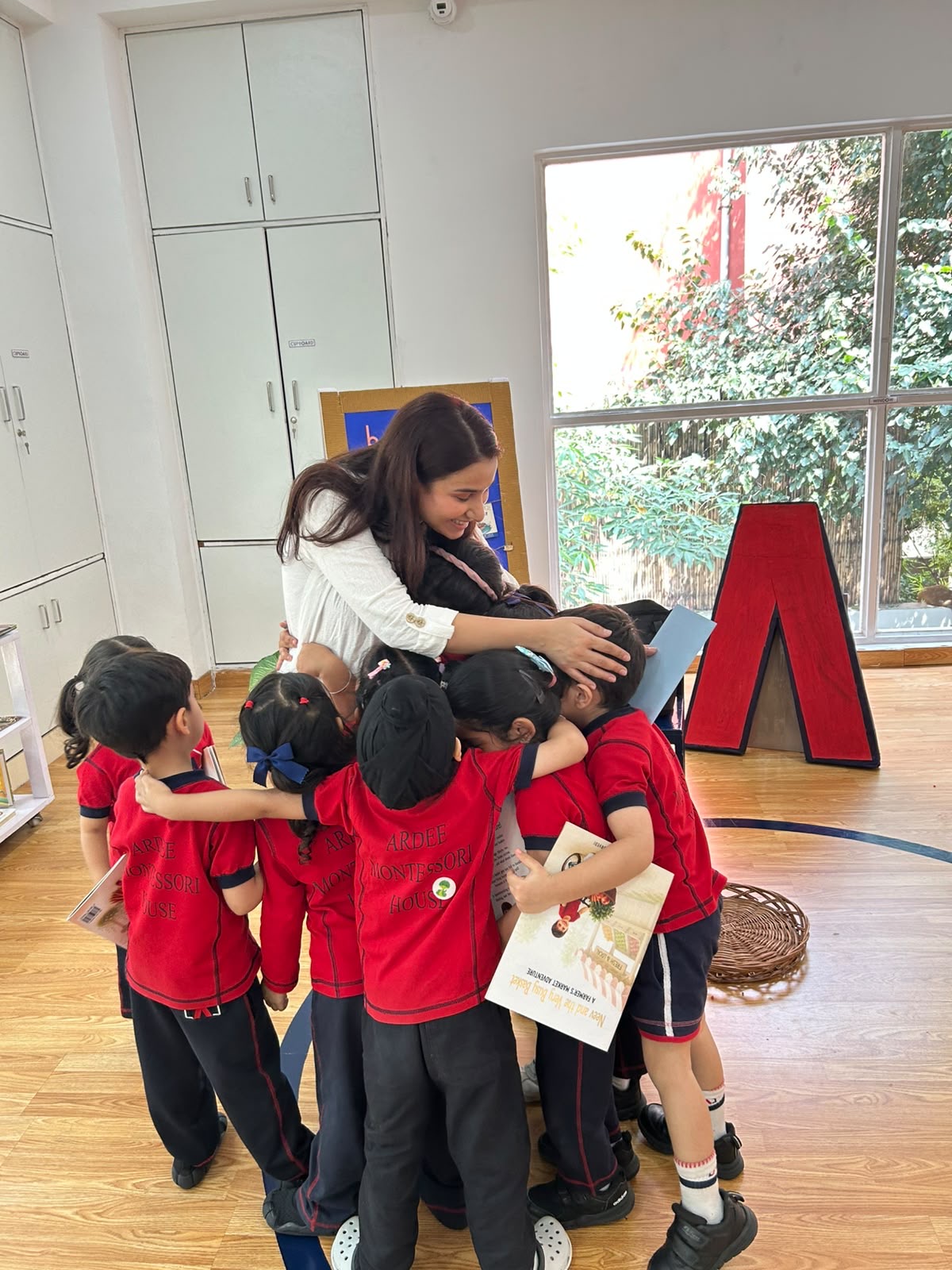 Spardha Chaturvedi sharing a group hug with children after a book session